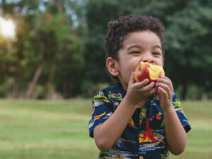 criança comendo maçã